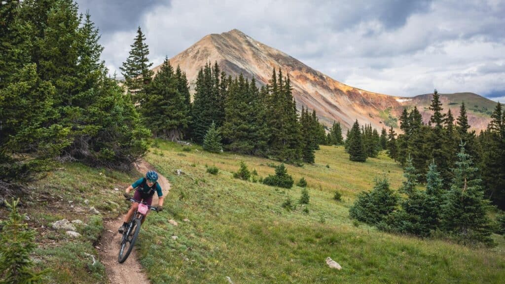 Mountain Games Athlete Haley Dumke rides her bike through a scenic mountain trail